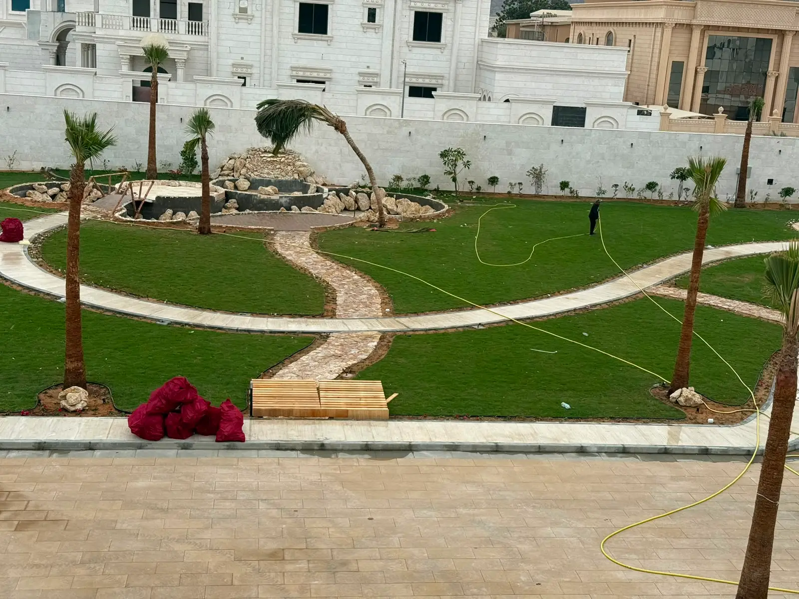 Landscaped estate courtyard with lawns, palms and paved walkways