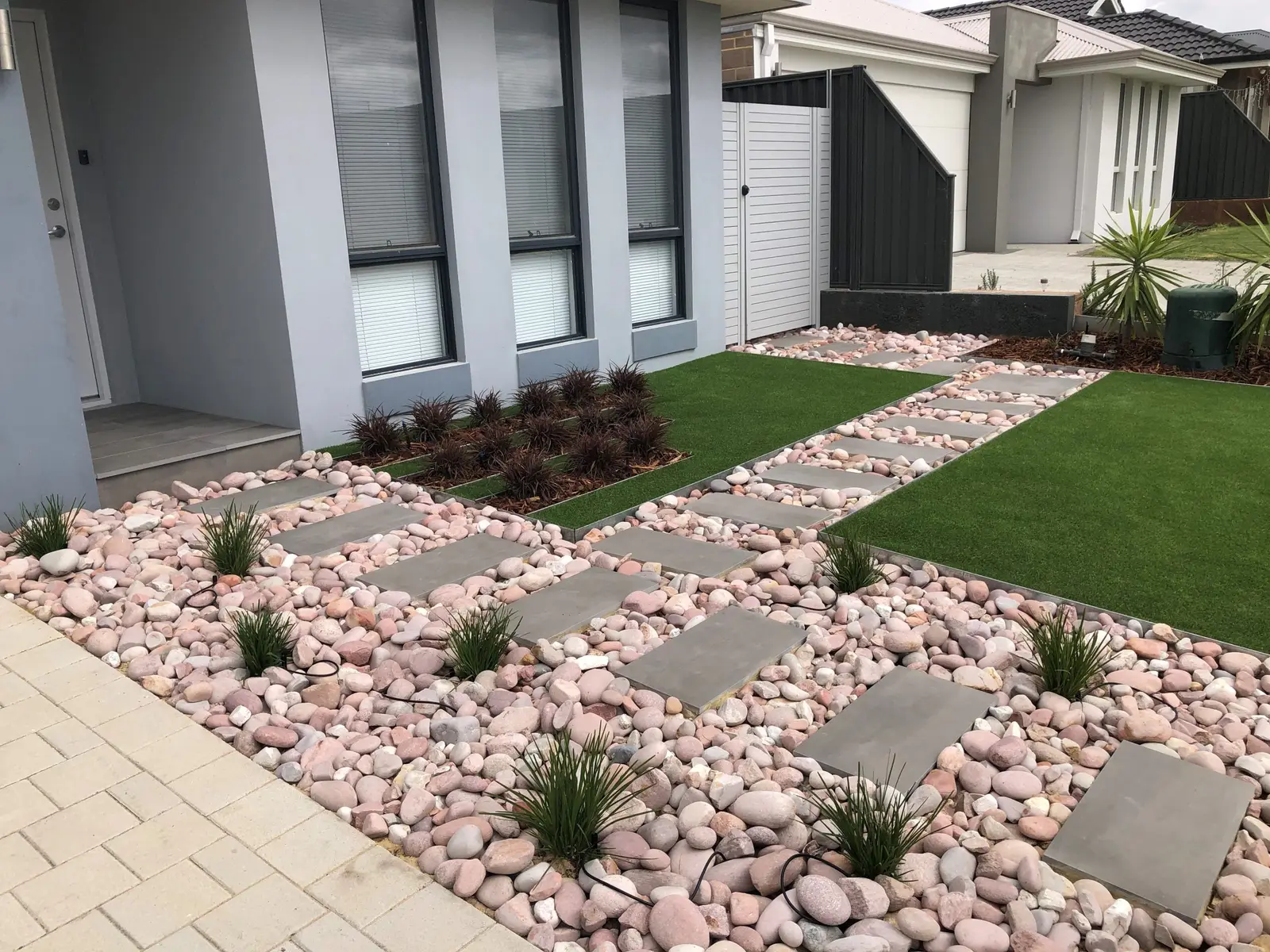 Modern hardscaping with pavers, gravel and grass strips at a villa